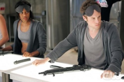 Jaden (Tiffany Hines)and Thom (Ashton Holmes)assemble MP5s blindfolded with other recruits