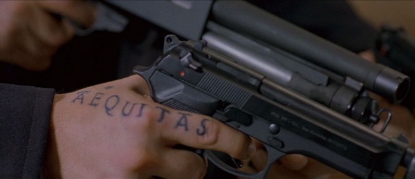 Close up of the Beretta in Connor's hand The tattoo on his hand is Latin 