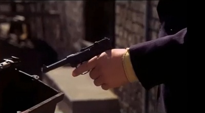 Egon Olsen holds the water pistol in hand